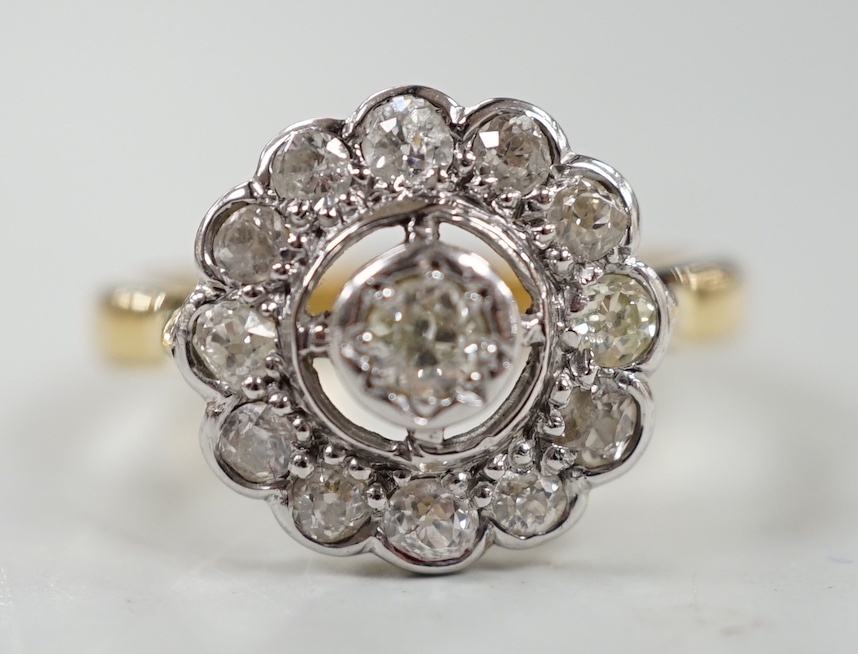 An 18ct and illusion set diamond circular cluster ring, size N, gross weight 5.1 grams.